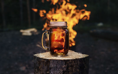 Close-up of drink in jar against fire