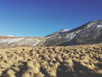 Scenic view of desert against clear blue sky