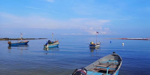 Boats moored in sea against sky