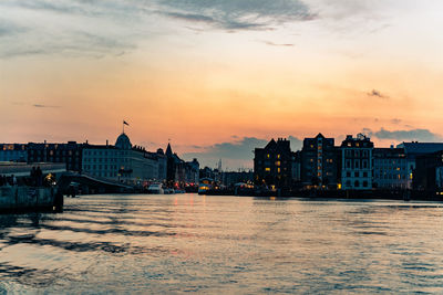 View of buildings at waterfront during sunset