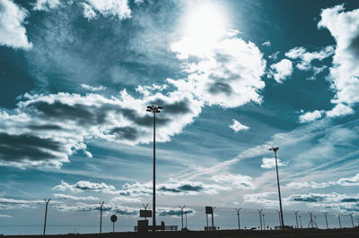 Low angle view of floodlight against cloudy sky