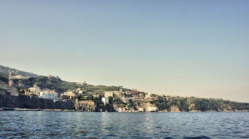 Townscape by sea against clear sky