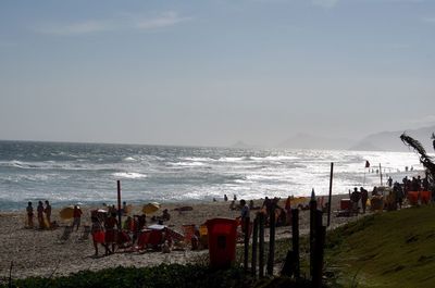 Group of people on beach against sky