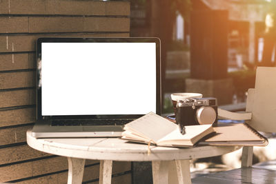 Close-up of laptop with blank screen at sidewalk cafe