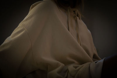 Rear view of woman standing against black background