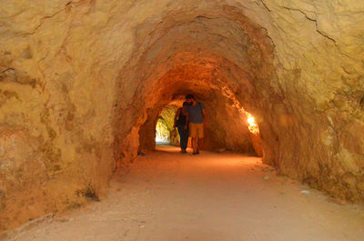 Couple walking in illuminated tunnel