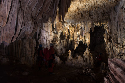 Rear view of man standing on rock in cave