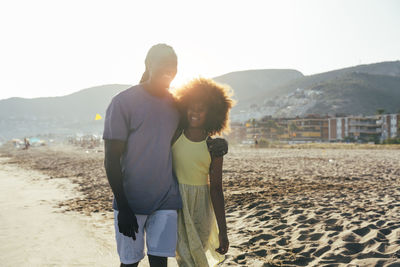 Happy father walking with daughter at beach