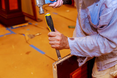 Midsection of carpenter working in workshop