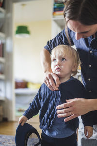 Man getting blond toddler son ready at home