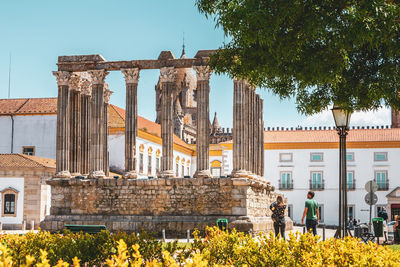 People by historic building against sky