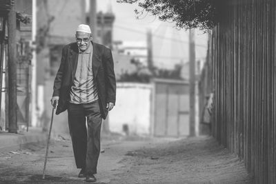 Full length of man walking with cane