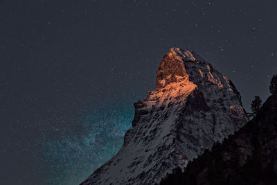 Low angle view of rock formation against sky at night