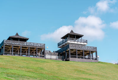 Low angle view of building on field against sky