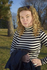 Portrait of young woman holding leather jacket