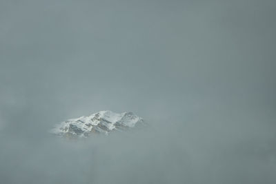 Snow covered land against clear sky