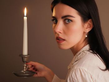 Close-up of young woman lighting candles