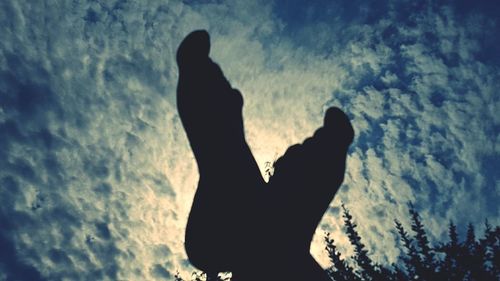 Low angle view of silhouette tree against cloudy sky