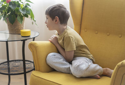 Young woman sitting on sofa at home