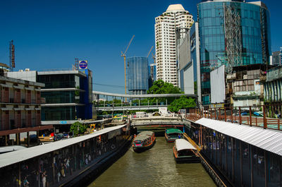 Bridge over canal amidst buildings in city against sky