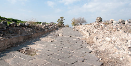 Footpath amidst rocks against sky