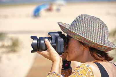 Side view of woman photographing with camera