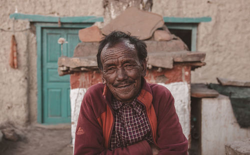 Portrait of man standing against building