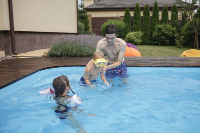 Full length of father and daughter in swimming pool