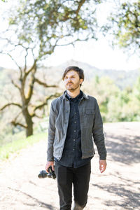 Young man hiking outdoors with camera in northern california