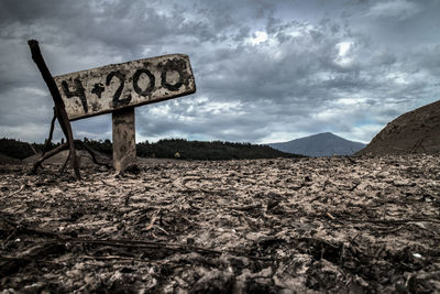 Low angle view of signboard against dramatic sky