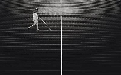 Rear view of man walking on staircase