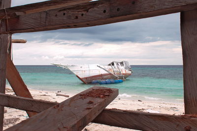 Close-up of deck chairs on beach against sky