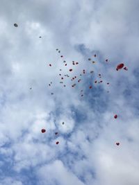 Low angle view of balloons flying against sky