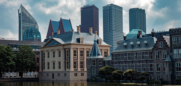 Buildings in city against cloudy sky