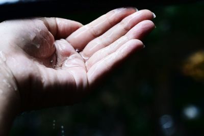 Cropped wet hand of woman in rain