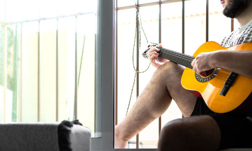 Man playing guitar at home