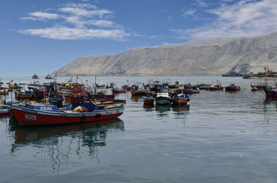 Boats moored in lake against sky