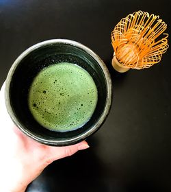 Close-up of hand holding tea cup on table