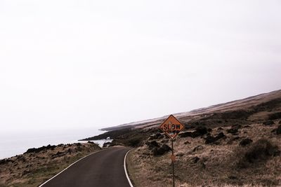 Road passing through landscape against clear sky