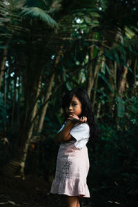 Portrait of a girl standing in forest