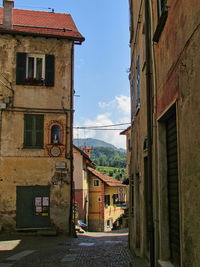 Street amidst buildings in town against sky