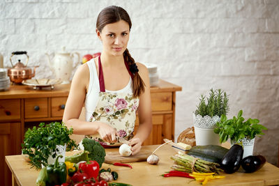 Portrait of woman preparing food on kitchen island at home