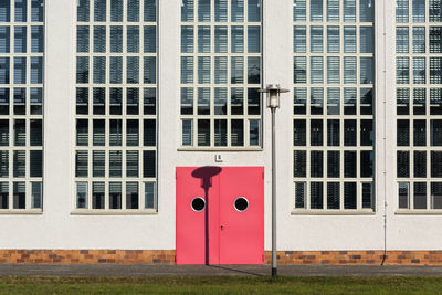Two-leaf red door with the portholes and the street lamp
