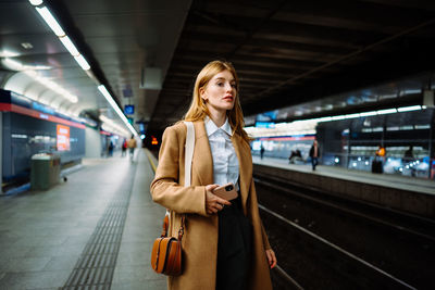 Portrait of young woman standing in subway