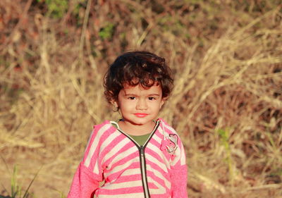 Indian beautiful little male child photo in which child stands outside in nature and blur background