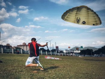 Full length of a man bicycling on grass against sky