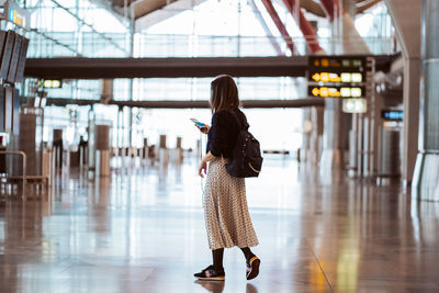 Rear view of woman standing on floor