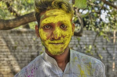 Portrait of man covered with yellow face powder during holi festival