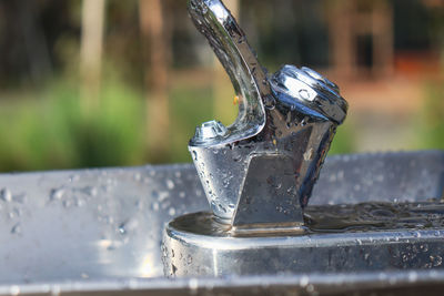 Close-up of water drops on metal water fountain