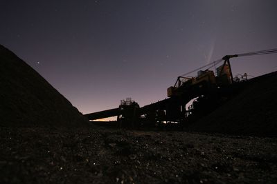 Low angle view of machinery on field against sky at night